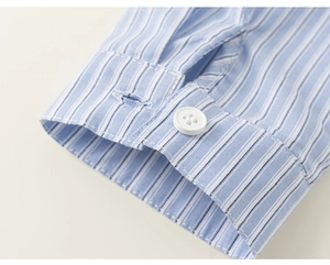 Detail of blue striped shirt cuff featuring white buttons and precise stitching texture