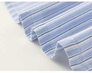 Macro shot of blue and white striped shirt fabric texture with detailed stitching