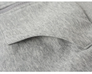 Detail shot of gray knit hoodie showing premium cotton texture and durable side pocket stitching
