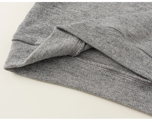 Close-up detail of grey knitted fabric texture and double-needle stitching on cuff