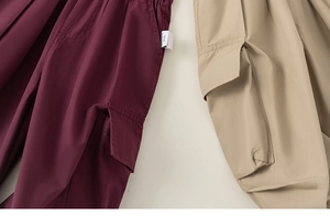 Detailed comparison of burgundy and khaki cargo pants with large flap pockets and woven texture