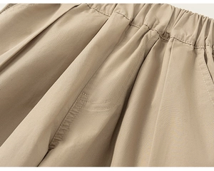 Detail of khaki kids cargo pants featuring elastic waistband and reinforced stitching