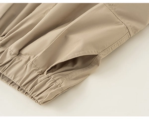 Detailed macro shot of the elastic waistband and side pocket on khaki cargo pants