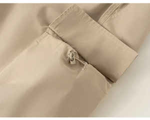 Detail view of khaki cargo pants featuring a flap pocket and adjustable drawstring toggle