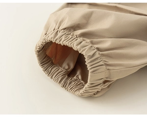 Detailed macro view of beige cargo pants elastic cuff showing fabric texture and stitching