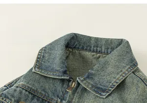 Close-up detail of classic lapel collar and metal zipper on children's denim jacket