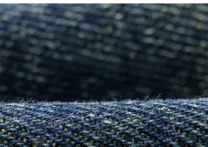 Macro shot of dark blue denim fabric showing detailed texture and high-quality weave pattern