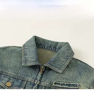Close-up of vintage wash denim jacket with lapel collar and embroidered letter detail