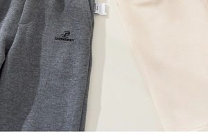 Detail of embroidered logo and size label on knit casual trousers for children