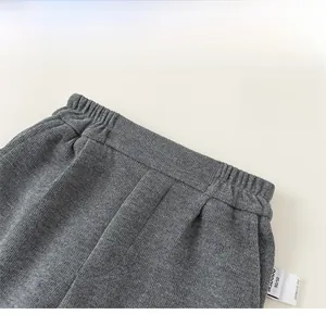Detail of grey knitted children pants featuring an elastic waistband and soft cotton fabric