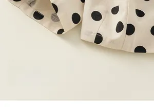 Close-up of cotton-linen fabric texture with black polka dots on beige pants