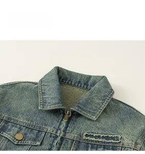 Detail of vintage washed denim jacket with classic lapel and distressed frayed edges