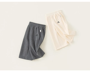 Detail of dark grey and off-white loose cotton trousers for girls with embroidery