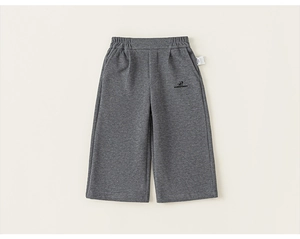 Detail of grey knitted toddler trousers showing elastic waistband and brand embroidery