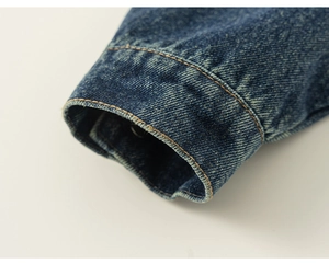Macro detail of dark blue denim sleeve cuff with contrast yellow double stitching