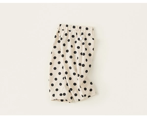Detail view of cotton leisure trousers for kids with black polka dots and elastic waist