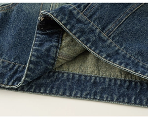 Macro shot of dark blue denim jacket hem with durable double stitching and metal zipper detail