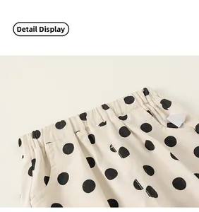 Close-up of children's beige polka dot pants featuring elastic waist and side pocket