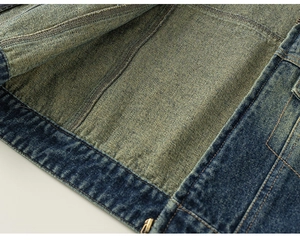 Detail of dark blue denim jacket showing vintage lining and orange double-stitched seams