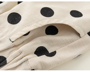 Detail of children's cotton-linen pants with black polka dots and slanted pocket side view