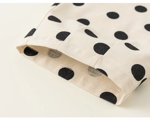 Macro view of cotton-linen trousers with black polka dots and high-quality hem stitching