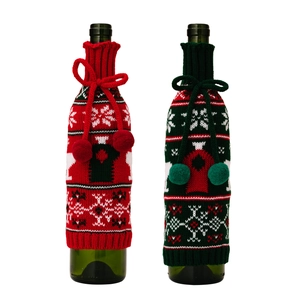 Knitted Christmas wine bottle covers with reindeer patterns and pom poms in red and green
