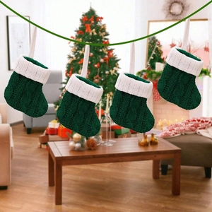 Set of four green cable-knit mini Christmas stockings with white trim for tree decoration