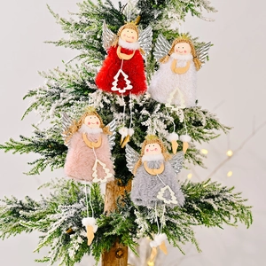Set of four plush Christmas angel ornaments with silver glitter wings on a snowy tree