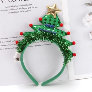 Detail of glowing green Christmas tree headband with red pom-poms and gold star topper