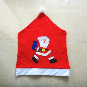 Détail de la housse de chaise Père Noël rouge avec pompon blanc et applique en feutre