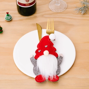 Christmas gnome cutlery holder featuring a red hat and grey heart suit on a dinner plate