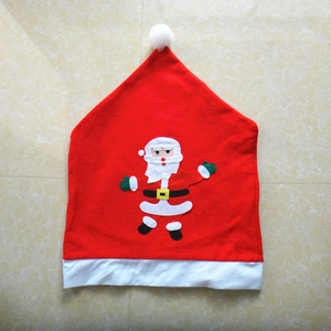 Détail de la housse de chaise Père Noël rouge avec pompon blanc et applique sur marbre