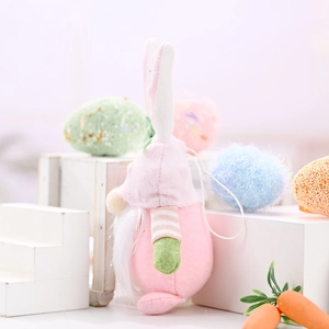 Easter gnome plush doll with rabbit ears and beard among colorful eggs and carrots