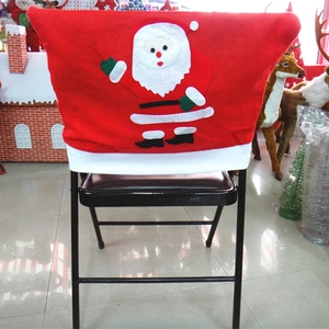 Détail d'une housse de chaise de Noël rouge avec un décor de Père Noël en dessin animé
