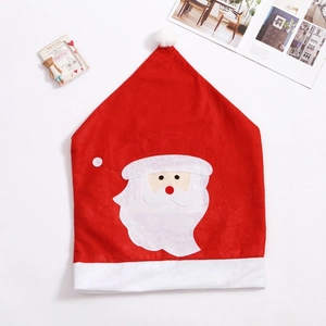 Détail de la housse de chaise Père Noël avec barbe blanche et décor de bonnet rouge