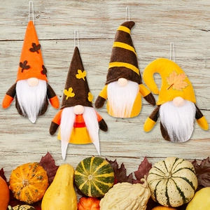 Set of 4 autumn gnome ornaments with pumpkin and maple leaf decorations on wood background