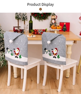 Detail of grey Christmas chair covers with Santa Claus and Snowman prints in dining setting