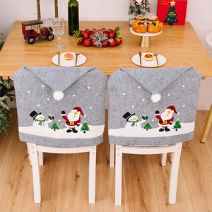 Detail view of two gray Christmas chair covers with Santa and snowman on white chairs