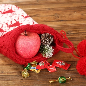 Knitted Christmas stocking with reindeer and snowflake patterns on dark wood background