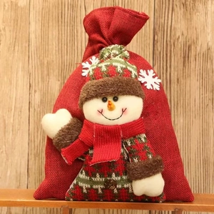 Roter Weihnachtsbeutel mit 3D-Schneemann-Puppe auf rustikalem Holzgrund für Geschenke
