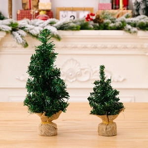 Set mini alberi di Natale artificiali con base in juta su sfondo camino festivo