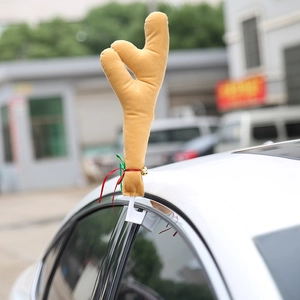 Christmas car reindeer antlers with red green ribbons and golden bell on side window