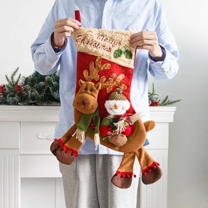 Large Christmas stocking with 3D snowman and reindeer decorations on festive fireplace