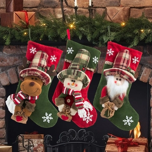 Three-piece Christmas stocking set featuring Santa, snowman, and reindeer on a cozy fireplace