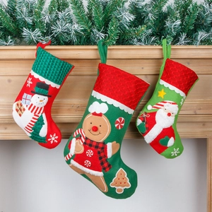 Three-piece Christmas stocking set featuring Santa and Gingerbread man on wooden mantel