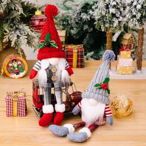 Gnomi di Natale nordici in peluche con cappelli di maglia e gambe lunghe su tavolo festivo