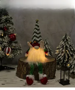 Close-up of glowing Christmas gnome with green striped hat on rustic wooden stump