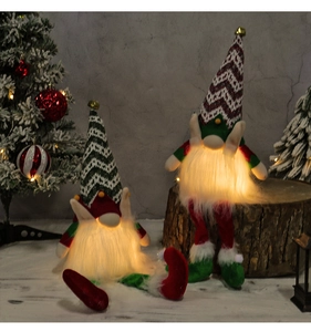 Close-up of glowing LED Christmas gnomes with warm lights and festive knitted hats