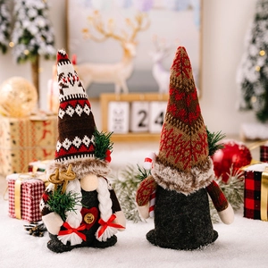 Christmas gnome dolls with knitted hats and pine branch props in cozy festive setting
