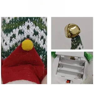 Detail of Christmas elf plush showing red felt hat, golden bell, and battery compartment